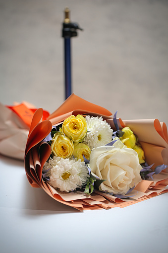 A beautiful bouquet of flowers with a variety of vibrant blossoms, displayed on a table with ample space for text or objects.