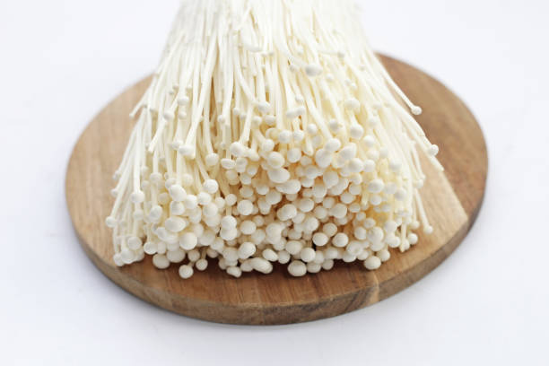 istock Fresh Enoki mushrooms on wooden cutting board 2121826986