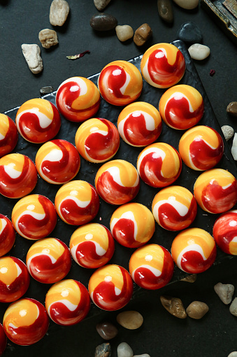 A table is adorned with a multitude of red and yellow marbles, creating a vibrant and eye-catching display.