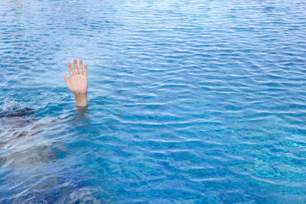 Hand in swimming pool water, Drown concept