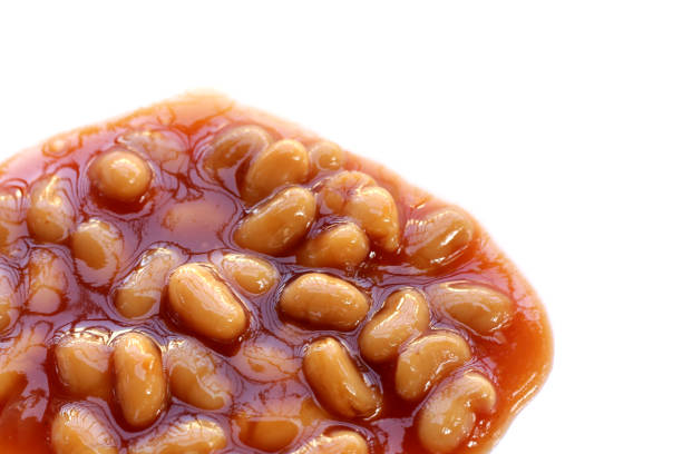 Close-up view of glossy brown beans resting together, showcasing their rich colors and textures under natural light.