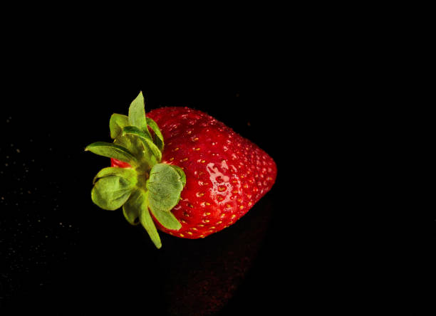 istock Strawberry rest on a black surface, a vibrant product from nature's bounty 2121862918
