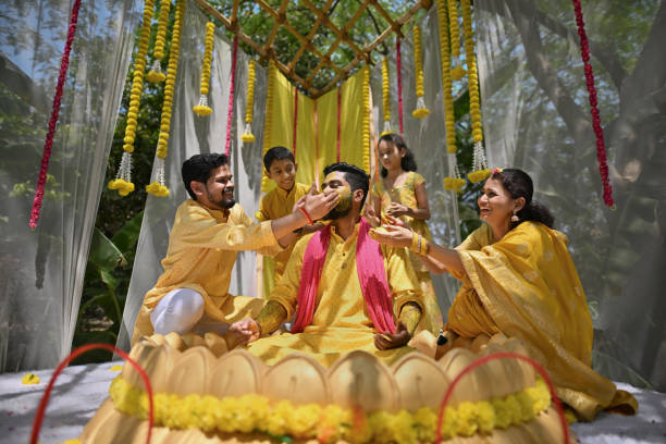 istock Family adorns Groom with turmeric paste  during his haldi ceremony 2121875984