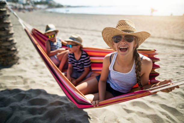 istock Cute kids relaxing on hammock on beach 2121880148