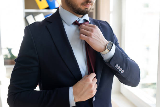 istock Businessman adjusts his tie by hand 2121896663