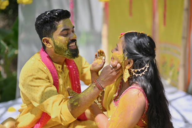 Close-up shot of a bride and groom in yellow attire apply turmeric paste to each other during their haldi ceremony Indian Bride & Groom enjoying their Haldi ceremony. The Haldi ceremony is one of the most loved pre-wedding rituals of Hindu weddings in India where the bride and the groom are smeared with turmeric paste. It signifies the start of the Hindu wedding rituals. haldi ceremony stock pictures, royalty-free photos & images