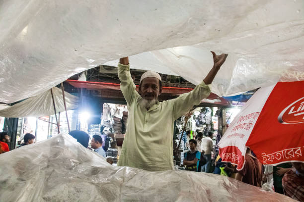 A busy street in Old Delhi, India, showing vendors, a frying pan, and a young boy preparing food, encapsulating the vibrant essence of urban life in a bustling marketplace.