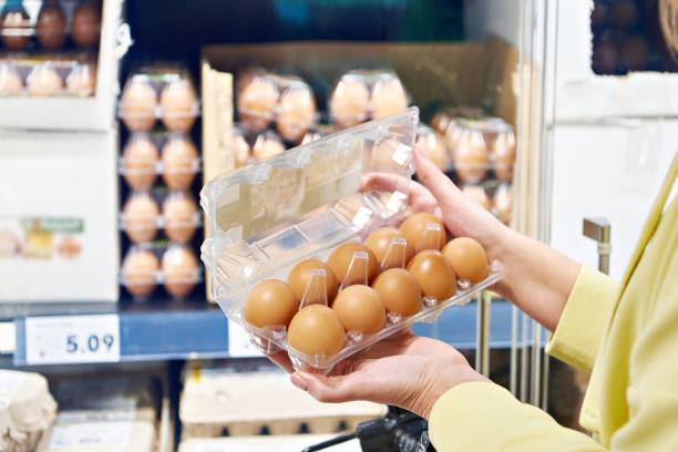 istock Hand with packages of eggs in store 2121908222