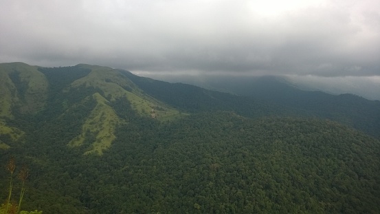 The Monsoon clouds enveloping Charmady Ghats in Karnataka, India, with lush tropical forests and hills