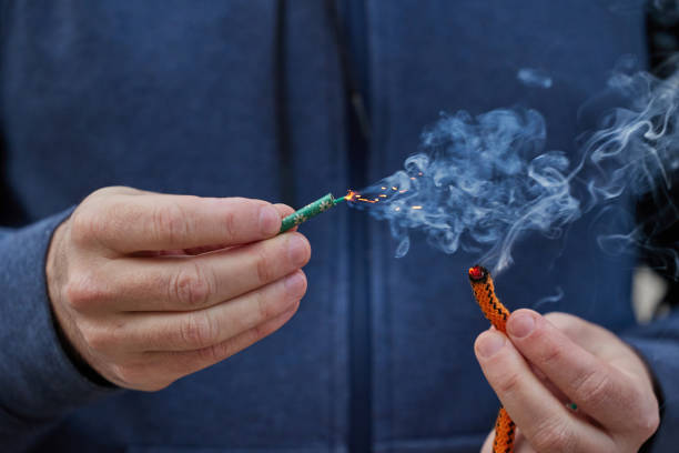 istock Close up of man hand lighting up a firecrackers with wick 2121977509