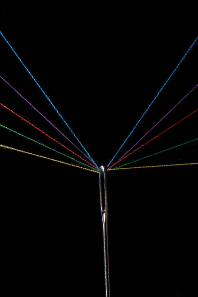 istock Eye sewing needle and multicolored threads passed through it black background. Concept hobbies and crafts. 2121984473