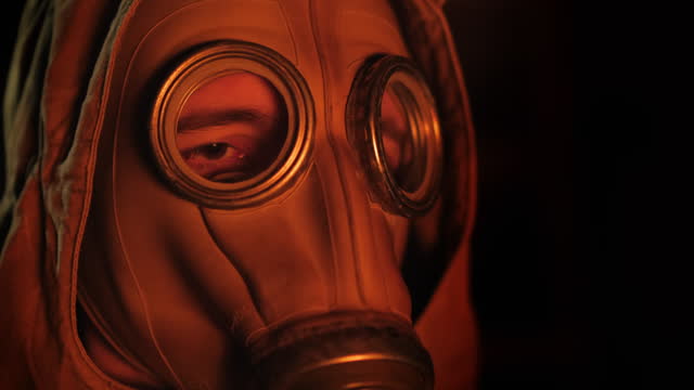 A person in a gas mask lights a fire of a fire