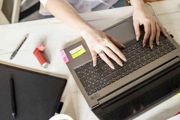 istock Woman is using a asthma pump, inhaler during an asthma attack while working from her home office. Emotional and physically stress. Modern virtual financial advisors and consultations. Remote work, business, freelance, online shopping, e-learning. 2122020131
