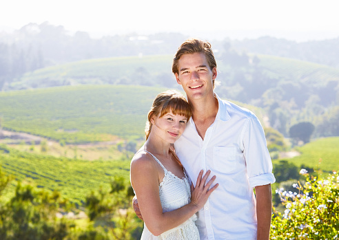 Happy couple in love in an idyllic wine farm setting.