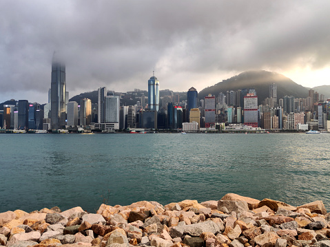 Victoria Harbor and Hong Kong island skyline viewed from West Kowloon waterfront promenade.