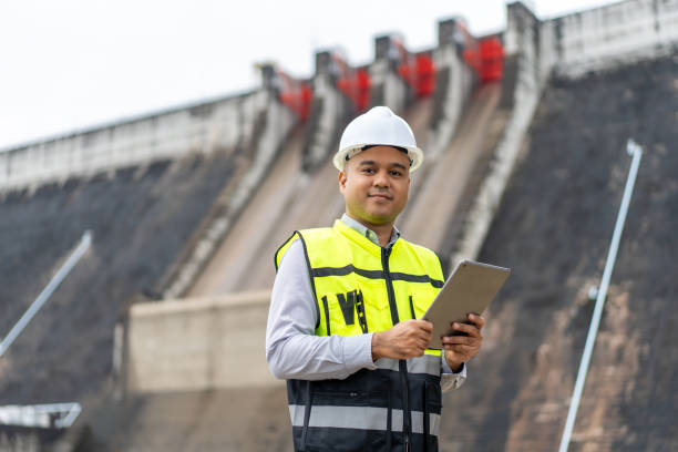 istock Professional asian maintenance engineer man with safety helmet in construction site dam with hydroelectric power plant and irrigation. Manager engineer man working with tablet at project big building. 2122058089