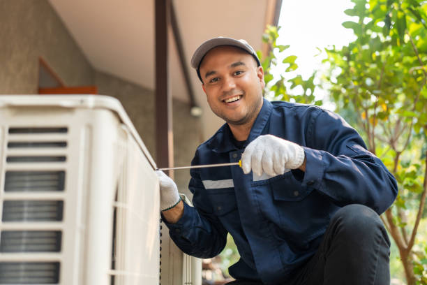 Air conditioner service outdoor checking fix repair. Air conditioner cleaning technician He opened the front cover and took out the filters and washed it. He in uniform wearing rubber stock photo