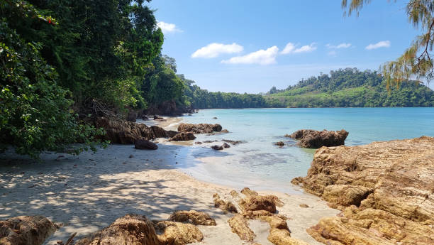 istock A peaceful beach scene where the waves gently caress the shore, surrounded by a scattering of rocks creating a tranquil atmosphere 2122104589