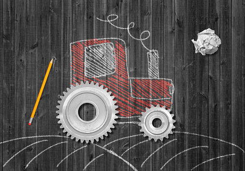 3d rendering of crumpled piece of paper, pencil, and chalk-drawn picture of tractor with real cogwheels instead of normal wheels on grey wooden background. Creative ideas. Finding solutions.