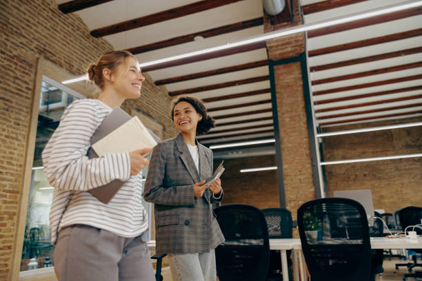 istock Smiling young diverse female employees talk during break time in stylish office 2122123875