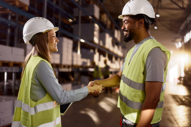 istock Happy black worker and female inspector shaking hands in storage room. 2122126981