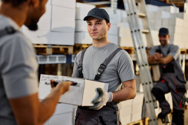 istock Manual workers scanning QR code of a package in storage room. 2122131597