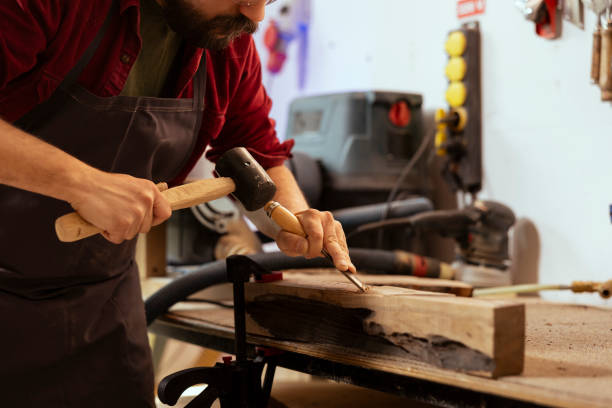 istock Skilled carpenter meticulously carving intricate designs into wood 2122183047