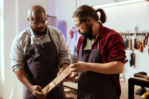 istock Manufacturer and apprentice analyzing piece of wood together, sizing it up 2122185094
