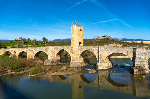 Medieval stone bridge in Frias, Spain\nView of a road next to a medieval bridge in the town of Frias in the province of Burgos - Spain.