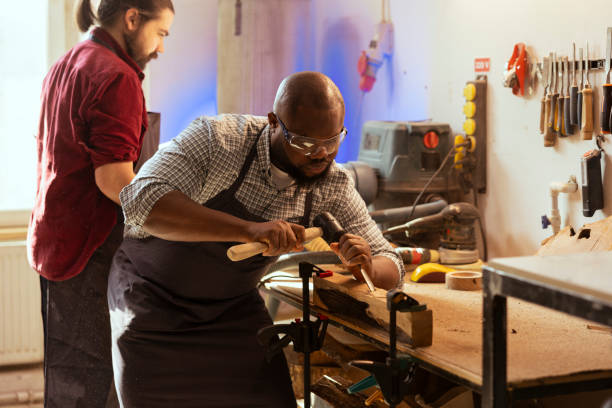 istock Cabinetmaker equipped with safety glasses, sculpting wooden surface 2122195281