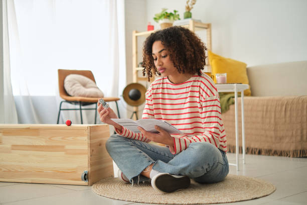Woman reading instructions to assemble a wardrobe at home
