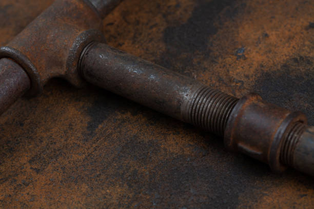 Rusty plumb tube on rusty metal wall background
