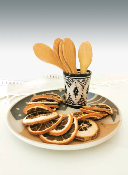 Dried orange in a decorative plate with spoons and ceramic cup stock photo