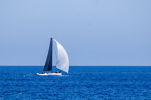 White sails of a yacht billowing in the wind, French Riviera