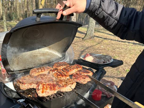 steaks, die auf dem grill gegart werden, nahaufnahme. ein mann kocht fleisch auf einem gasgrill. kochen im freien, picknick. - pork tenderloin dinner barbecue stock-fotos und bilder