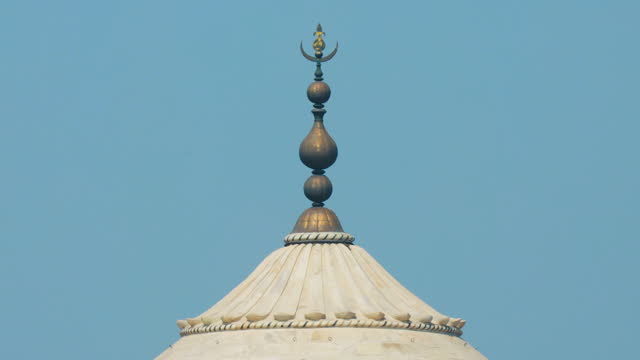 Taj Mahal in Agra, Uttar Pradesh, India. Close up of dome. crescent moon on the domes spire. Seven world wonders. Fabulous Taj mahal travel concept. indian islamic heritage at sunny day. air melts and shivers due to high temperature.