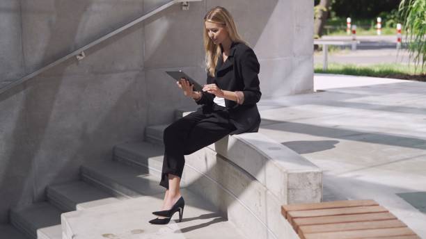 istock Professional Businesswoman Using Tablet on Concrete Steps 2122267164