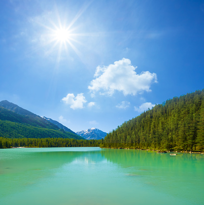 emerald lake in gren mountain valley under a sparkle sun