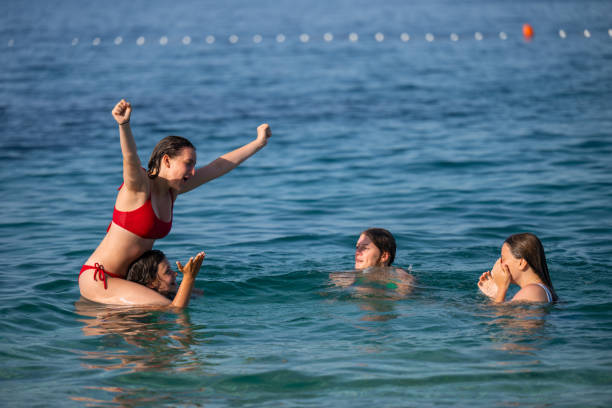 istock Young girls having fun in the sea 2122307409