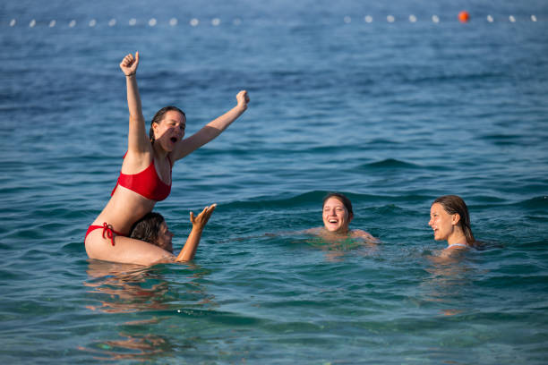 istock Young girls having fun in the sea 2122307912