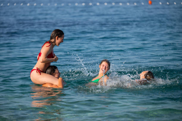 istock Young girls having fun in the sea 2122308435