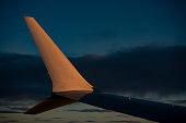 Close-up of airplane wing flying at sunrise