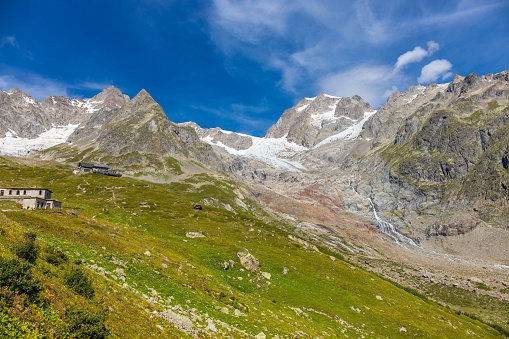 Val Veny beautiful mountains scenic landscape in summer with lakes and rock summits in the italian Alps near Courmayeur, Italy. Alpine mountain landscape of a green valley
