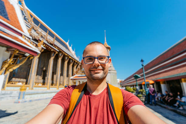 istock Young Man Taking Selfies At Wat Phra Kaew Complex (The Temple Of The Emerald Buddha) In Bangkok In Thailand 2122349436