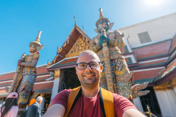 istock Young Man Taking Selfies At Wat Phra Kaew Complex (The Temple Of The Emerald Buddha) In Bangkok In Thailand 2122352072