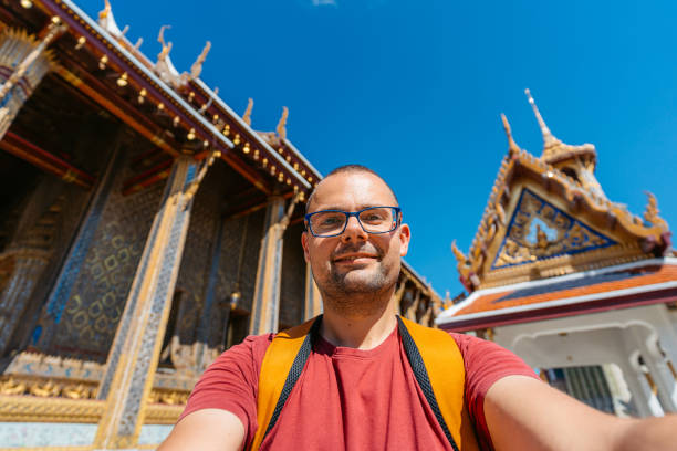 istock Young Man Taking Selfies At Wat Phra Kaew Complex (The Temple Of The Emerald Buddha) In Bangkok In Thailand 2122353699