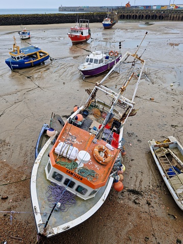 Multi-colored small boats in the sand in English port of Folkestone - on the dry until the tide comes back in