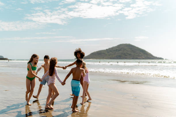 istock Kids friends playing on the beach 2122360433