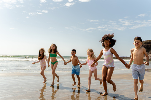 Friends children running through the beach