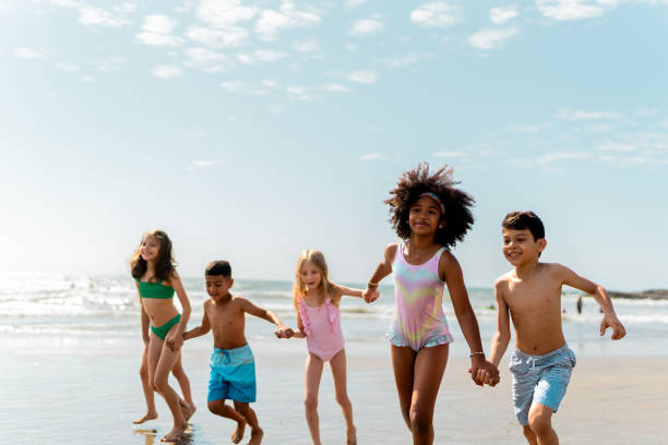 istock Friends children running through the beach 2122360966